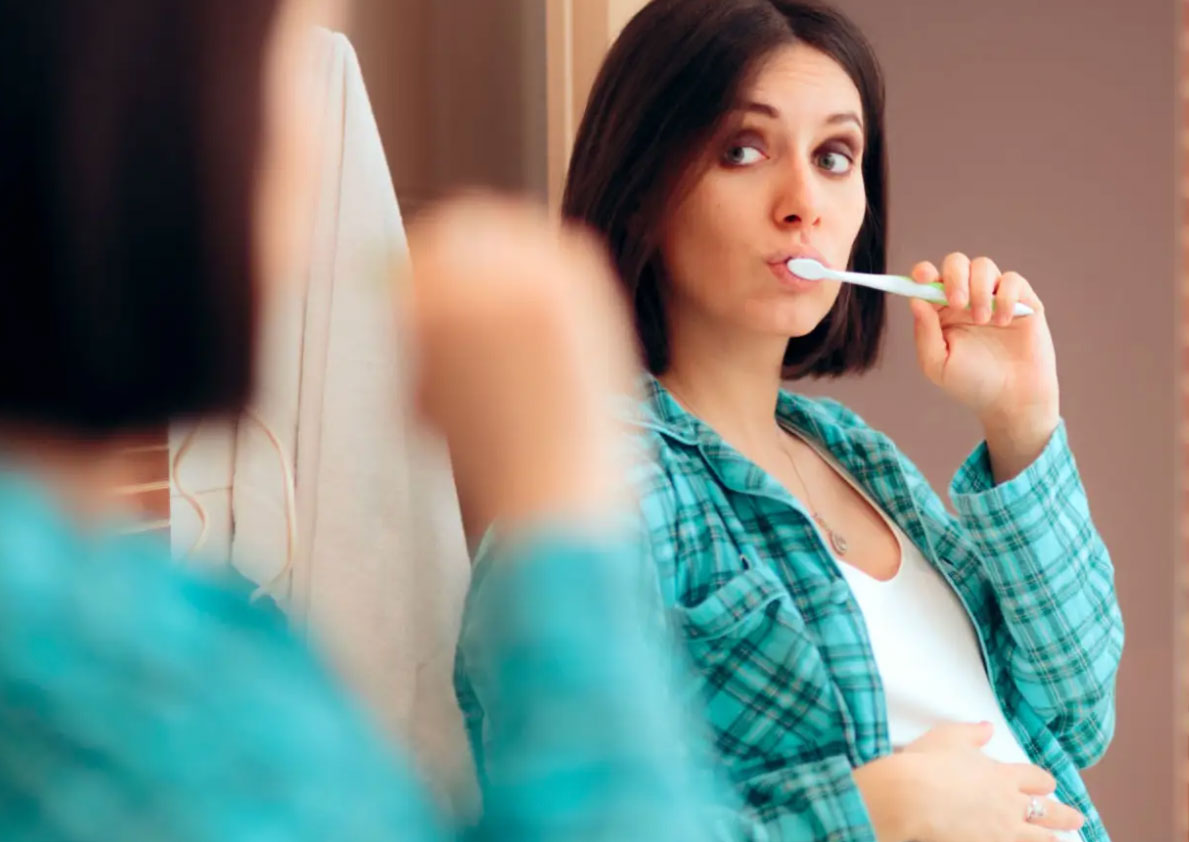 pregnant woman brushing teeth