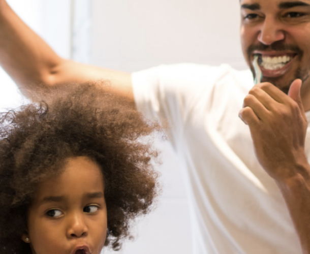 father and son brushing teeth
